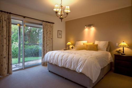 a bedroom with a bed and a large window at Mhara Downs Country Escape in Foster