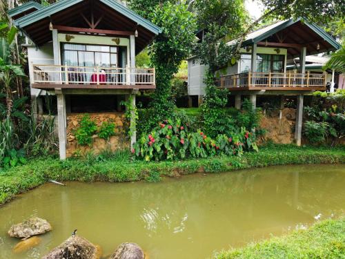 uma casa com dois deques ao lado de um lago em Rainforest Nest em Deniyaya