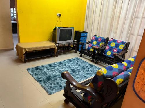 a living room with two chairs and a tv at Banglo Semi D Villa D Doa Maju in Kuala Terengganu
