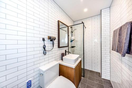 a bathroom with a toilet and a sink and a mirror at The Jade Hotel in Jeju