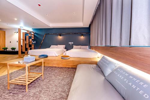 a bedroom with two beds and a couch at The Jade Hotel in Jeju