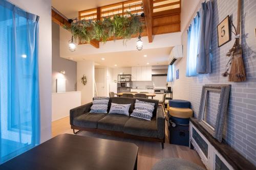 a living room with a couch and a table at trive osu east 最大7名宿泊可能 in Nagoya