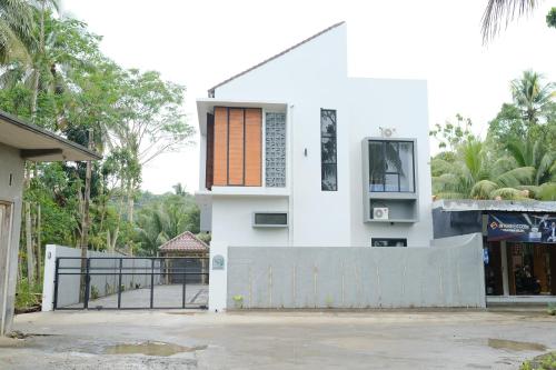 a white house with a gate and a fence at Kmanda House in Pangandaran