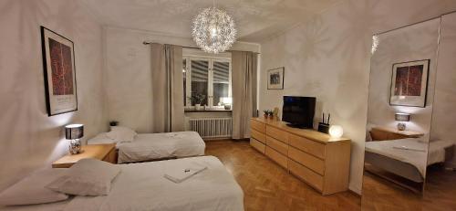 1 Schlafzimmer mit 2 Betten, einem TV und einem Kronleuchter in der Unterkunft City Apartments Triangeln in Malmö