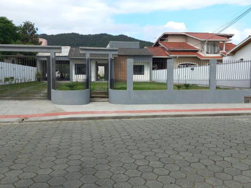 una casa con una valla al lado de una calle en Casa com piscina no Campeche en Florianópolis