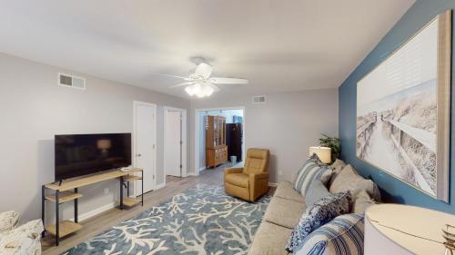 a living room with a couch and a tv at TURTLE'S NEST DUPLEX Duplex in Jekyll Island