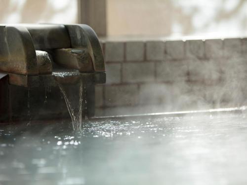 a water fountain with water coming out of it at adex Inn in Noboribetsu
