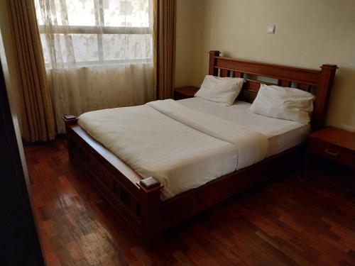 duże łóżko w sypialni z oknem w obiekcie Sky view three bedroom w mieście Nairobi