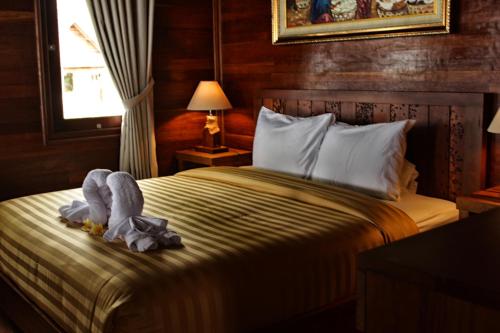 a bedroom with a bed with a blanket and a window at Mina Tanjung Hotel in Tanjung