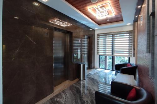 a lobby with black chairs and a large window at BATAM 1 HOTEL in Nagoya