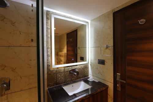 a bathroom with a sink and a mirror at Mastiff Hotel Dhanbad in Dhanbād