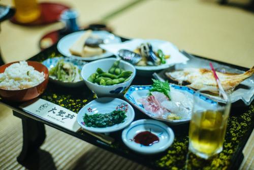 a table topped with bowls of food and a drink at 大聖坊 Daishobo in Tsuruoka