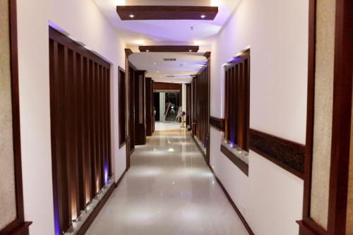 a corridor of a building with white walls and a long hallway at Athirappilly Residency Chalakudy in Kizhake Chālakudi