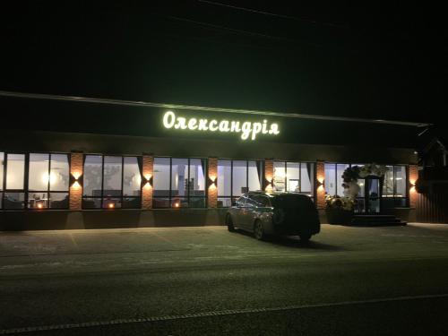 a car parked in front of a store at night at Карпатський Готель Олександрія in Mykulychyn