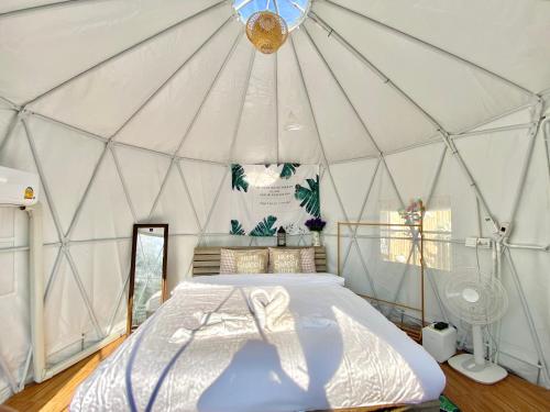 a large white tent with a bed in it at ดูดาวแคมป์ริมโขง in Chiang Khan