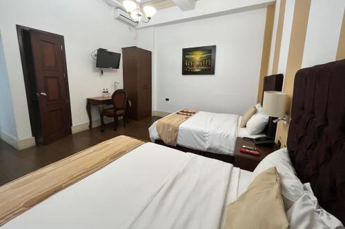 a hotel room with two beds and a table at Hotel Patrimonial by Greenfield in Guayaquil