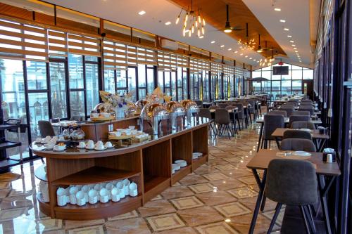 a restaurant with tables and chairs and windows at BATAM 1 HOTEL in Nagoya