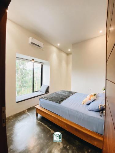 a bedroom with a bed and a window at Kmanda House in Pangandaran