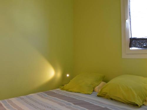 une chambre avec un lit aux murs jaunes et une fenêtre dans l'établissement Appt 2P cab. 4 pers avec piscine et parking - FR-1-229D-92, à Fleury
