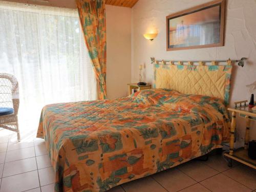 - une chambre avec un lit doté d'une couverture colorée et d'une fenêtre dans l'établissement Maison spacieuse 6 couchages, proche plage à La Guérinière, jardin clos, terrasse, calme - FR-1-224B-132, à La Guérinière
