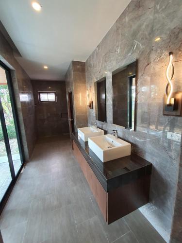 a bathroom with two sinks and a large mirror at Siri Thai Lodges in Hua Hin