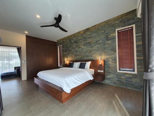 a bedroom with a bed and a ceiling fan at Siri Thai Lodges in Hua Hin