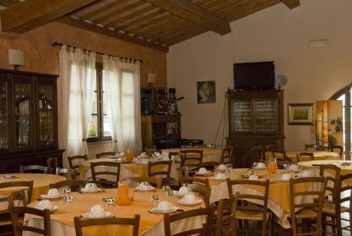 comedor con mesas y sillas y TV en Agriturismo Marrucola, en San Miniato