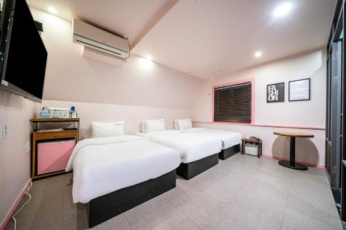 Habitación con 2 camas y TV de pantalla plana. en No25 Hotel Yeonsan en Busan