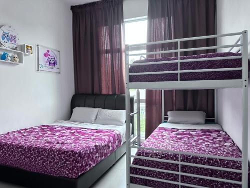 een slaapkamer met twee stapelbedden en een raam bij Feel Homestay in Cameron Highlands