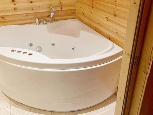 a white bath tub in a bathroom with wooden walls at 8 person holiday home in Norheimsund-By Traum in Norheimsund