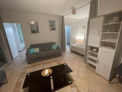 sala de estar con sofá y mesa en La Croisette appartement vue mer à 1mn de la plage + parking, en Filaos