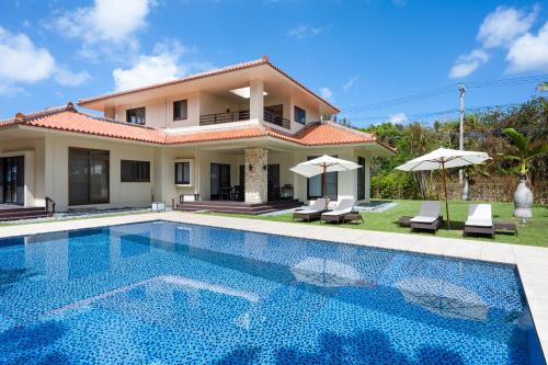 eine Villa mit einem Pool vor einem Haus in der Unterkunft Ocean Front Villa Ishigakijima Ⅰ in Ishigaki-jima
