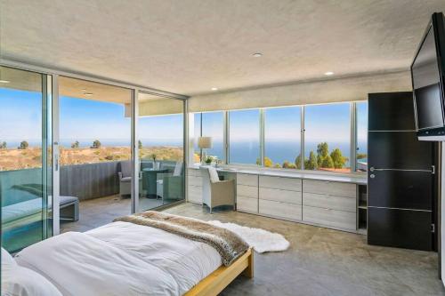 a bedroom with a bed and a view of the ocean at Malibu Glass House: Architectural w 180deg Views in Malibu