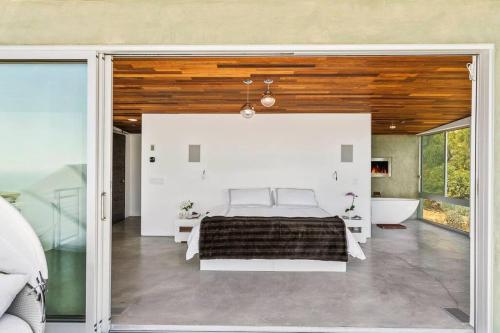 a bedroom with a bed and a tub in a room at Malibu Glass House: Architectural w 180deg Views in Malibu