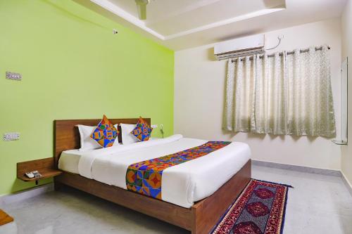 a bedroom with a large bed and a window at FabHotel Golden Hitech in Hyderabad
