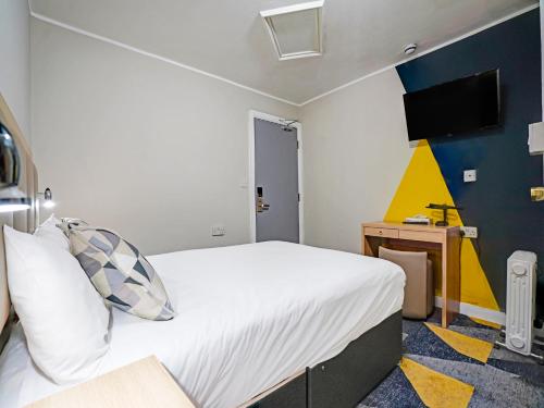 a bedroom with a bed and a tv on the wall at Weaste Hotel, West Manchester Hotel in Manchester