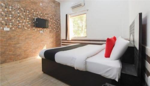 ein Schlafzimmer mit einem Bett mit einem roten Kissen in der Unterkunft Hotel J.S. Plaza By WB Inn in Agra