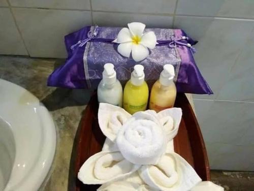 een dienblad met handdoeken en een bloem op een wastafel bij KOHMOOK THE SUN GREAT RESORT in Ko Mook
