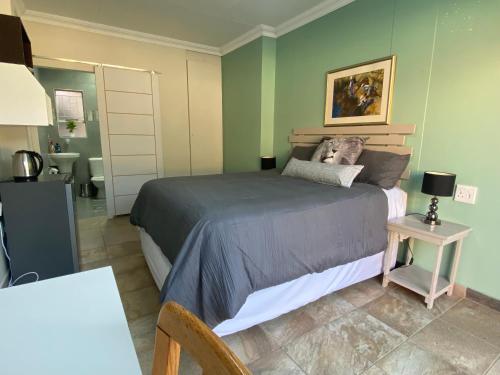 a bedroom with a large bed and a bathroom at Protea Guesthouse in Newcastle
