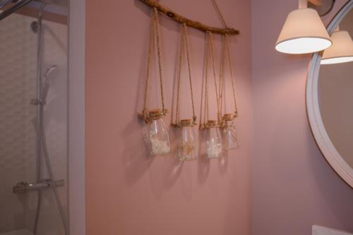 a bathroom with four glass bottles hanging on the wall at Les 3 Bérets chambres d'hotes in Oloron-Sainte-Marie