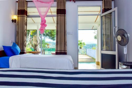 a bedroom with a bed and a view of a balcony at Ella Nimal Nest Inn in Ella