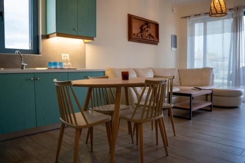 cocina y sala de estar con mesa y sillas en Sea and city apartments en Cos