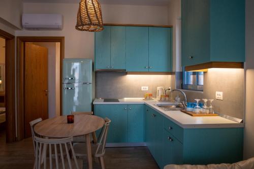 une cuisine avec des placards bleus et une table en bois dans l'établissement Sea and city apartments, à Kos