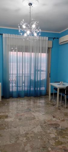 a room with a chandelier and a table and a window at La Feluca Rooms & Breakfast in Messina