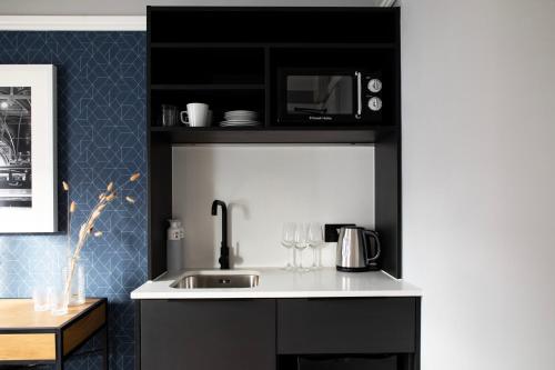eine Küche mit einer Spüle und einer Mikrowelle in der Unterkunft Bob W Hyde Park in London