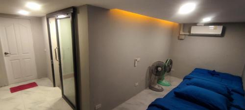 una camera con letto blu e ventilatore di MediLeaf Hostel a Haad Rin