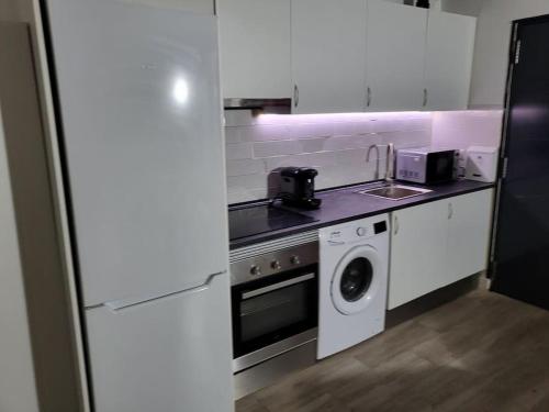 a kitchen with a stove and a washing machine at Precioso apartamento de 2 habitaciones. in Madrid