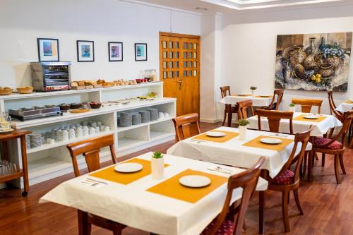 un ristorante con tavoli e sedie in una stanza di Hotel Villa San Juan a San Juan de Alicante
