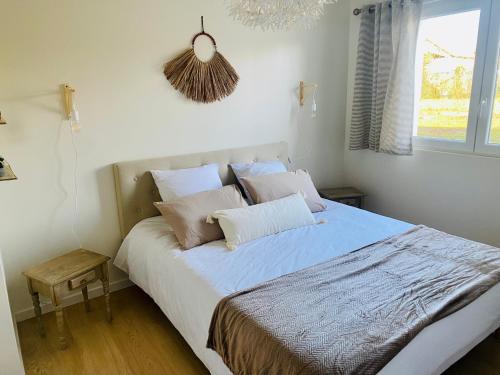 Schlafzimmer mit einem Bett mit weißer Bettwäsche und Kissen in der Unterkunft Le Biclou- 3 chambres in Bazincourt-sur-Saulx