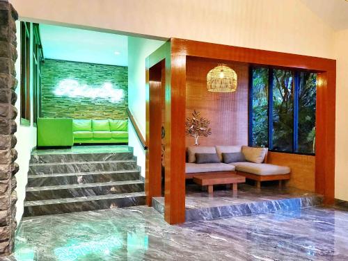 a living room with a couch and a stair case at The Batu Hotel & Villas in Batu